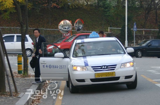 한 수험생이 택시를 타고와 시험장 앞에서 내리는 모습.