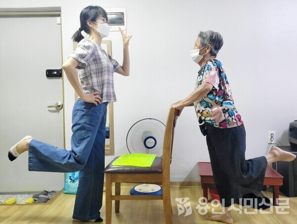 한 노인이 방문건강관리 간호사와 함께 근력 강화 체조를 하고 있다.