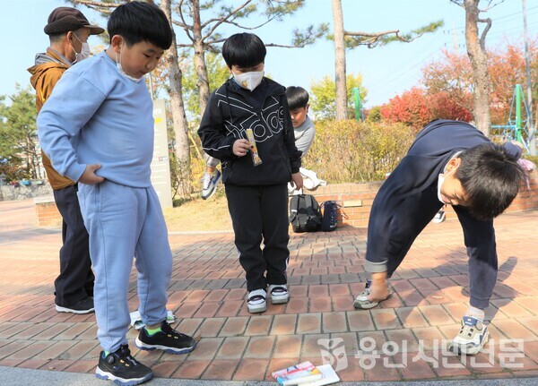 성산초등학교 학생들이 유방동 어린이공원에서 딱지치기 놀이를 하고 있다.