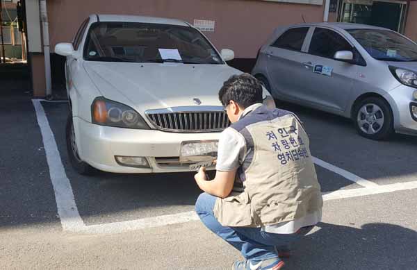 처인구 직원이 자동차세 체납차량 번호판을 떼고 있다.(자료사진)