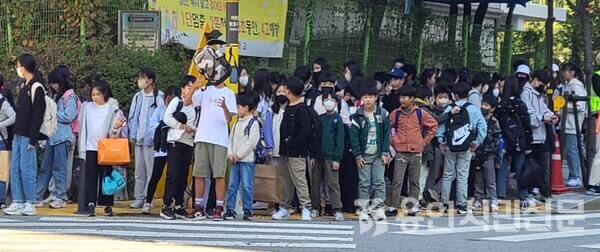 신호대기 장소가 협소해 위험성이 제기됐던 상현초등학교 앞 사거리 횡단보도에 학생들이 서 있는 모습.