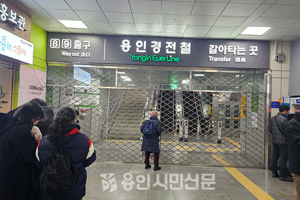 분당선 기흥역에서 용인경전철로 환승하려는 승객들이 닫혀 있는 문 앞을 서성이고 있다.
